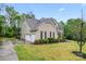 Exterior view of a two-story home with a three car garage, manicured lawn, and lush landscaping at 6312 Crosshall Pl, Waxhaw, NC 28173