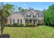 Charming two-story home featuring a lush lawn, landscaped garden, and classic architectural details at 6312 Crosshall Pl, Waxhaw, NC 28173