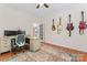 Functional home office with multiple monitors, guitars on the wall, and a patterned rug at 6312 Crosshall Pl, Waxhaw, NC 28173