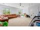 This open playroom area features multiple windows, carpet flooring, and a gray ceiling fan at 6312 Crosshall Pl, Waxhaw, NC 28173