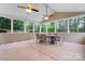 Spacious screened porch with stone flooring, ceiling fans, and wooded backyard views at 6312 Crosshall Pl, Waxhaw, NC 28173