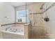 This primary bathroom features a glass shower with decorative tile and a large jacuzzi at 6312 Crosshall Pl, Waxhaw, NC 28173