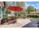 Backyard patio featuring a red umbrella, seating, shade, and a manicured lawn at 6420 Conifer Cir, Indian Trail, NC 28079