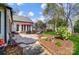 Backyard patio with chairs, an umbrella, foliage, and a hanging chair on a sunny day at 6420 Conifer Cir, Indian Trail, NC 28079