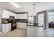 Modern kitchen with a dark granite countertop island, tiled floor and white cabinets at 6420 Conifer Cir, Indian Trail, NC 28079