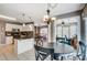 A kitchen island connects to a dining area with views to an office space at 6420 Conifer Cir, Indian Trail, NC 28079