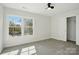 Bright bedroom featuring a ceiling fan, closet, and large windows with outside views at 68 Cabarrus W Ave, Concord, NC 28025