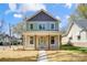 Charming two-story home featuring a covered front porch with wooden columns and a light green front door at 68 Cabarrus W Ave, Concord, NC 28025