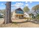 Attractive two-story home with a covered front porch nestled among mature trees in a residential area at 68 Cabarrus W Ave, Concord, NC 28025