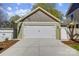 Two car garage with a light green exterior paint, white doors and a concrete driveway at 68 Cabarrus W Ave, Concord, NC 28025