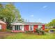Charming red brick home with a cozy front porch and well-manicured lawn at 6800 Deanwood Pl, Charlotte, NC 28217