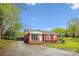 Quaint red brick home featuring a well-kept lawn and inviting front entrance at 6800 Deanwood Pl, Charlotte, NC 28217
