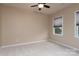 Bright bedroom featuring neutral walls, carpet flooring, a ceiling fan, and a window at 7217 Cedarfield Rd, Charlotte, NC 28227