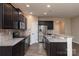 Modern kitchen featuring dark cabinets, granite countertops, stainless steel appliances, and wood flooring at 7217 Cedarfield Rd, Charlotte, NC 28227