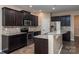 Modern kitchen featuring dark cabinets, granite countertops, stainless steel appliances, and wood flooring at 7217 Cedarfield Rd, Charlotte, NC 28227