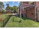 Landscaped backyard with a well-maintained lawn, black fencing, and a patio with a grilling area at 1008 Autumn Ln, Concord, NC 28025