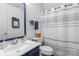 Bright bathroom with a modern vanity, framed mirror, and a shower with stylish striped shower curtains at 1008 Autumn Ln, Concord, NC 28025