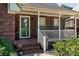 Inviting front porch with brick steps, white railings, and a beautifully patterned outdoor rug at 1008 Autumn Ln, Concord, NC 28025