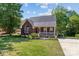 Charming brick home with a well-manicured lawn, a white picket fence, and beautiful landscaping at 1008 Autumn Ln, Concord, NC 28025
