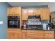Kitchen with wooden cabinets, granite counters, and backsplash with gas range at 1008 Autumn Ln, Concord, NC 28025