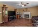 Spacious living room with hardwood floors, a fireplace, and a large TV for entertainment at 1008 Autumn Ln, Concord, NC 28025