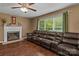 Comfortable living room featuring a fireplace, a ceiling fan, and a large leather couch at 1008 Autumn Ln, Concord, NC 28025