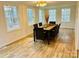 Bright dining room with wooden table and seating for eight next to bright windows with a wooded view at 1031 Lester Trl, Iron Station, NC 28080