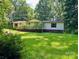 Ranch style home featuring a long front porch and well-maintained yard surrounded by lush trees at 1031 Lester Trl, Iron Station, NC 28080