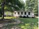 Quaint ranch-style home surrounded by lush greenery and mature trees at 1031 Lester Trl, Iron Station, NC 28080