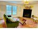 Comfortable living room featuring a fireplace, stylish decor, and large windows offering wooded views at 1031 Lester Trl, Iron Station, NC 28080