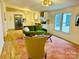 Cozy living space merging into a modern kitchen with white cabinets and stainless steel appliances at 1031 Lester Trl, Iron Station, NC 28080