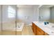 Spacious bathroom with double vanity, large mirror, tub, and enclosed shower at 10848 Tailwater St, Davidson, NC 28036