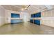 Spacious garage with blue cabinets along the wall and a door leading outside at 10848 Tailwater St, Davidson, NC 28036