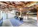 Spacious unfinished basement featuring an exposed ceiling, painted brick, and a cozy seating area with two chairs and a vibrant rug at 1110 S New Hope Rd, Gastonia, NC 28054