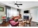 Bright living room with fireplace, large windows with sheer curtains, and a ceiling fan at 1110 S New Hope Rd, Gastonia, NC 28054