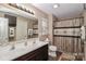 Bright bathroom with double vanity, tiled floors, and a decorative shower curtain at 1135 Valley St, Statesville, NC 28677
