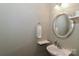 Bright powder room featuring a modern round mirror, stylish sink, and towel rack at 1135 Valley St, Statesville, NC 28677