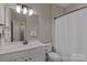 Well-lit bathroom featuring a white vanity, matching toilet, and shower at 119 Capital Ave # E, Mooresville, NC 28117