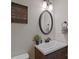 This bathroom has a wooden vanity with dark hardware, an oval mirror, and a framed quote on the wall at 119 Capital Ave # E, Mooresville, NC 28117