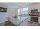 This kitchen features white cabinets, stainless steel appliances, a gray backsplash, and a granite island with pendant lighting at 119 Capital Ave # E, Mooresville, NC 28117