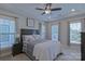 This main bedroom features a tray ceiling, a ceiling fan, and three windows for natural light at 119 Capital Ave # E, Mooresville, NC 28117