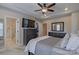This main bedroom features a tray ceiling, a ceiling fan, a walk-in closet, and an en-suite bathroom at 119 Capital Ave # E, Mooresville, NC 28117
