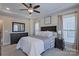 This main bedroom features a tray ceiling, a ceiling fan, and neutral colored walls and furniture at 119 Capital Ave # E, Mooresville, NC 28117