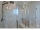This shower features a glass enclosure, a built-in bench, and gray-tiled walls at 119 Capital Ave # E, Mooresville, NC 28117