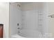 Bathroom showcasing a white tub-shower combo with tiled surround and built-in shelves at 12550 Mcgrath Dr, Charlotte, NC 28269