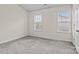 Comfortable bedroom with two bright windows, neutral walls, plush carpeting, and a closet door at 12550 Mcgrath Dr, Charlotte, NC 28269