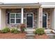 Inviting front entrance featuring a stone facade, black door with transom window, and manicured shrubs at 12550 Mcgrath Dr, Charlotte, NC 28269