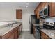 Well-equipped kitchen boasts granite countertops, stainless steel appliances, and warm wood cabinetry at 12550 Mcgrath Dr, Charlotte, NC 28269