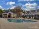 Community pool with lounge chairs, and a covered pavilion, surrounded by well-maintained landscaping at 12550 Mcgrath Dr, Charlotte, NC 28269