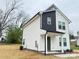 Side view of a charming two-story home with white siding and a welcoming front porch at 1406 Mason St, Kannapolis, NC 28081